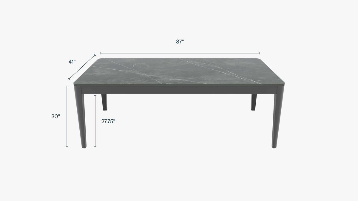 Sintered stone outdoor dining table in Mineral Gray, with sleek powder-coated aluminum legs, measuring 87” L x 41” W x 30” H.