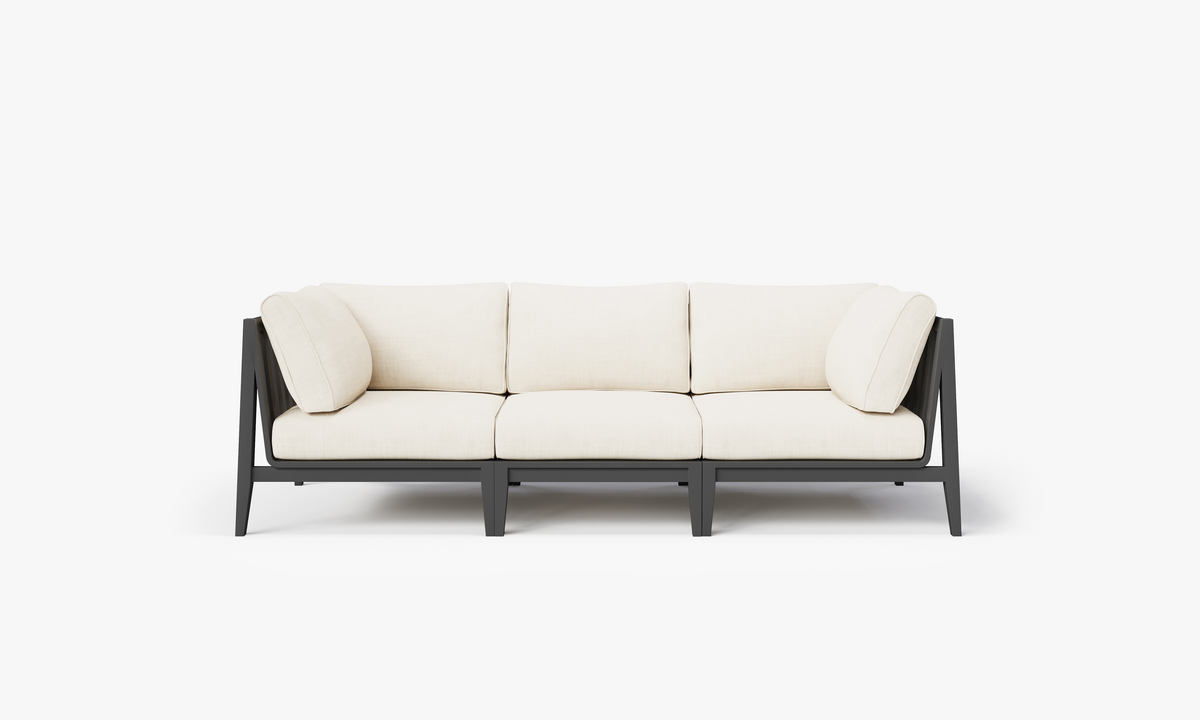 Charcoal aluminum outdoor sofa with three seats and cream-colored cushions, featuring a modular design and modern lines.