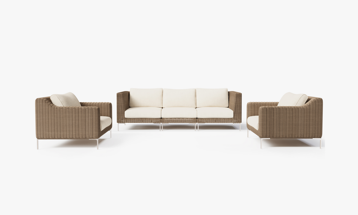 Handwoven brown wicker outdoor sofa set with two armchairs and three cushions, featuring polished stainless steel legs.