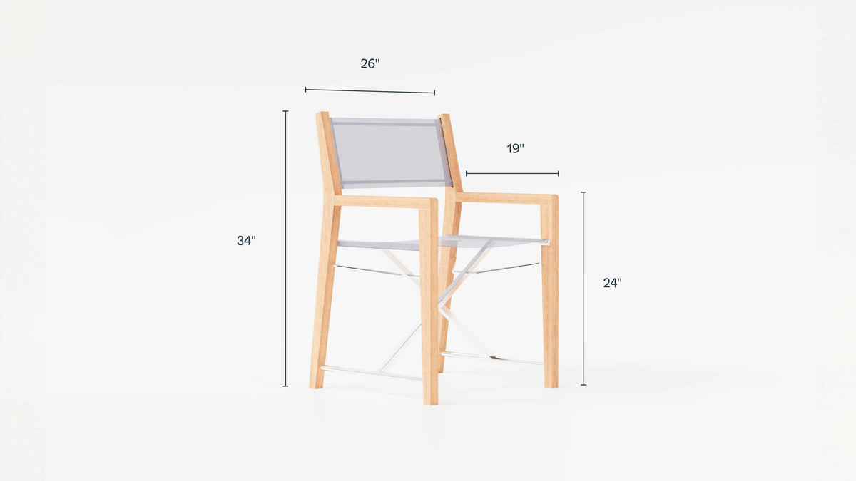 Outdoor teak director's chair with a natural wood frame and gray fabric seat, measuring 34 inches tall and 26 inches wide.