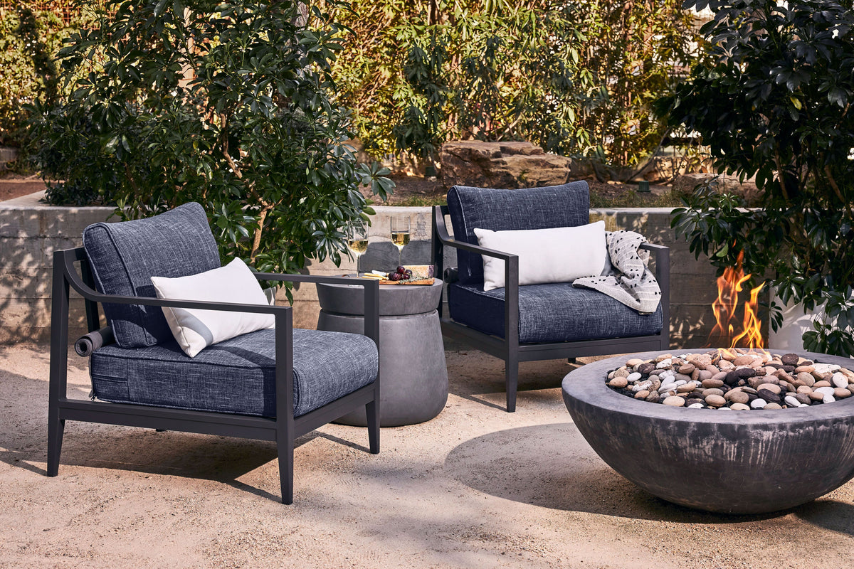 Charcoal aluminum outdoor sofa set with plush cushions, featuring two armchairs and a cozy fire pit.