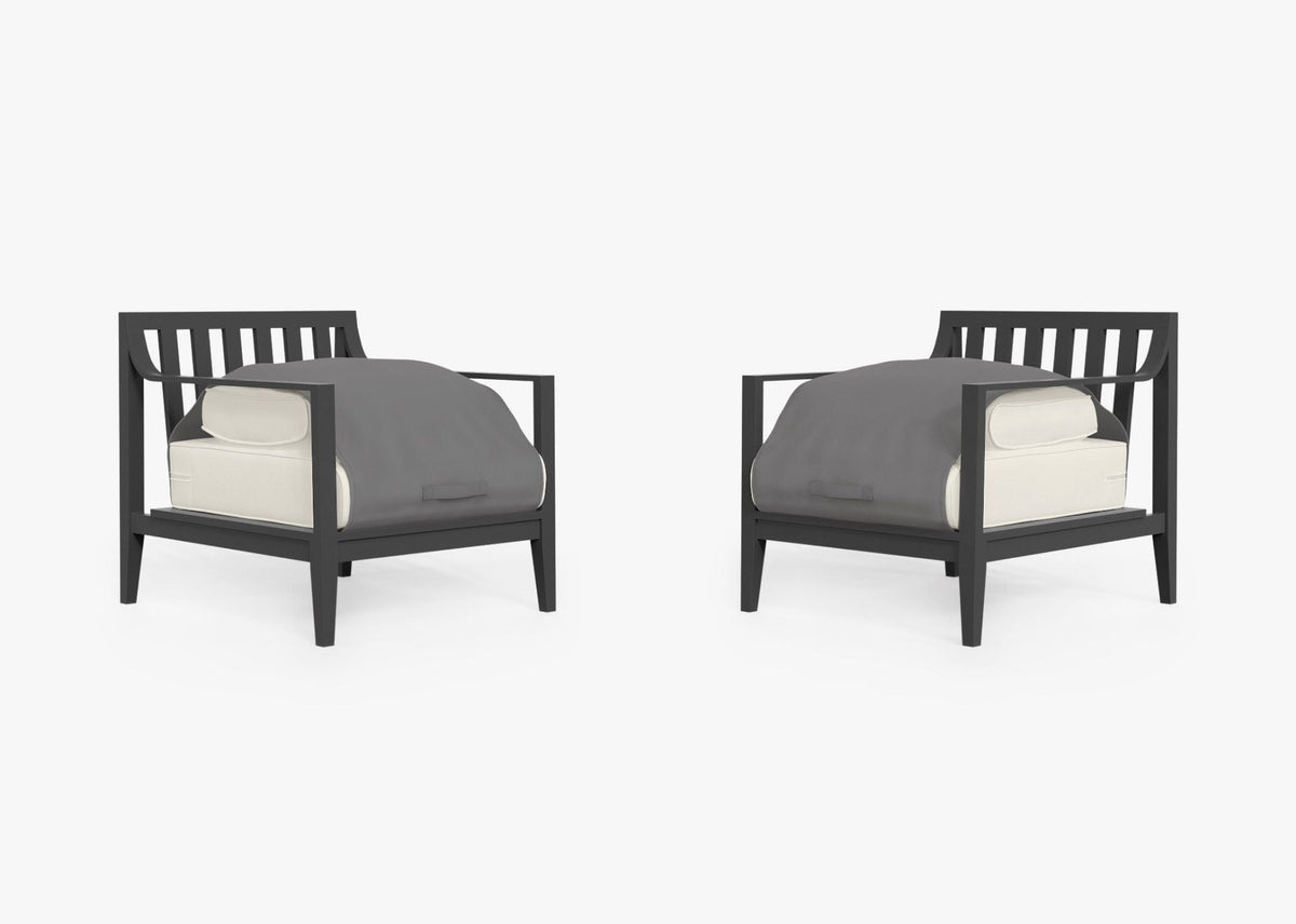 Charcoal aluminum outdoor armchair set with light cushion covers and a protective gray cover on each chair.