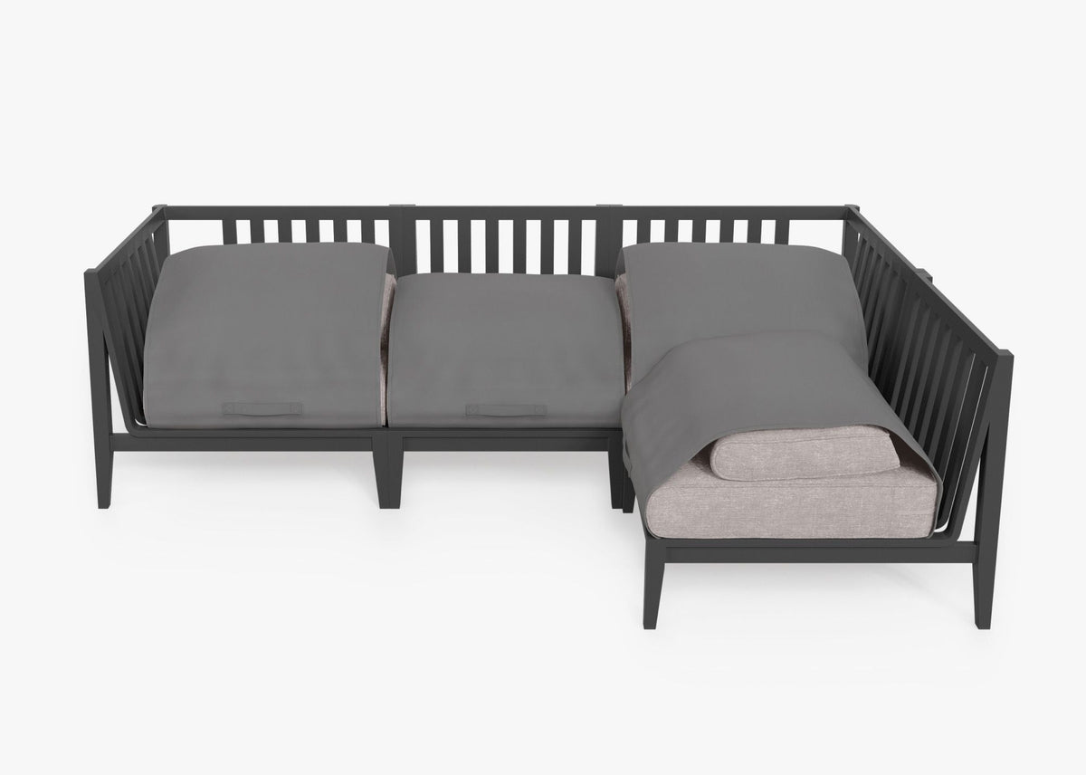 Charcoal aluminum L-shaped sectional sofa with layered cushions and integrated cover. Modular design for outdoor seating.