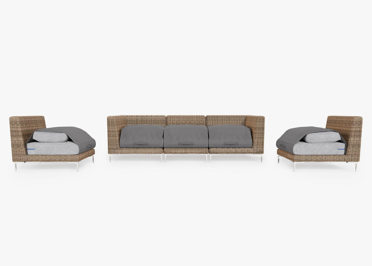 Handwoven brown wicker sofa with two armless chairs, layered gray cushions, modular design, and polished stainless steel legs.
