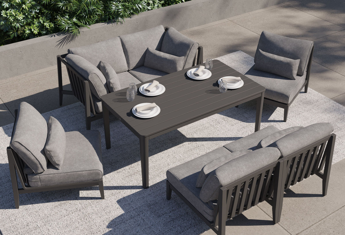 Charcoal aluminum U-shaped sectional with layered gray cushions, arranged around a dark patio table.