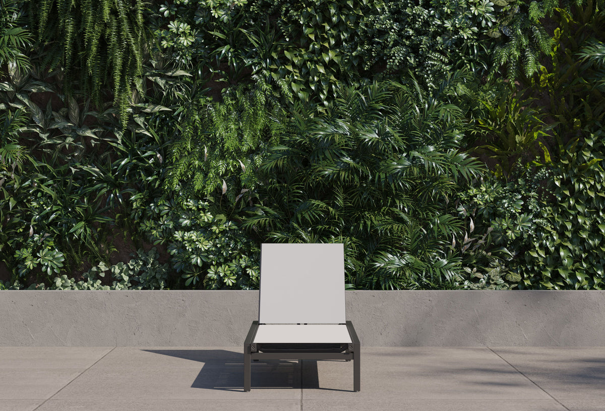 Aluminum Outdoor Infinity Chaise Lounge with a sleek frame and adjustable white sling, set against a lush green backdrop.
