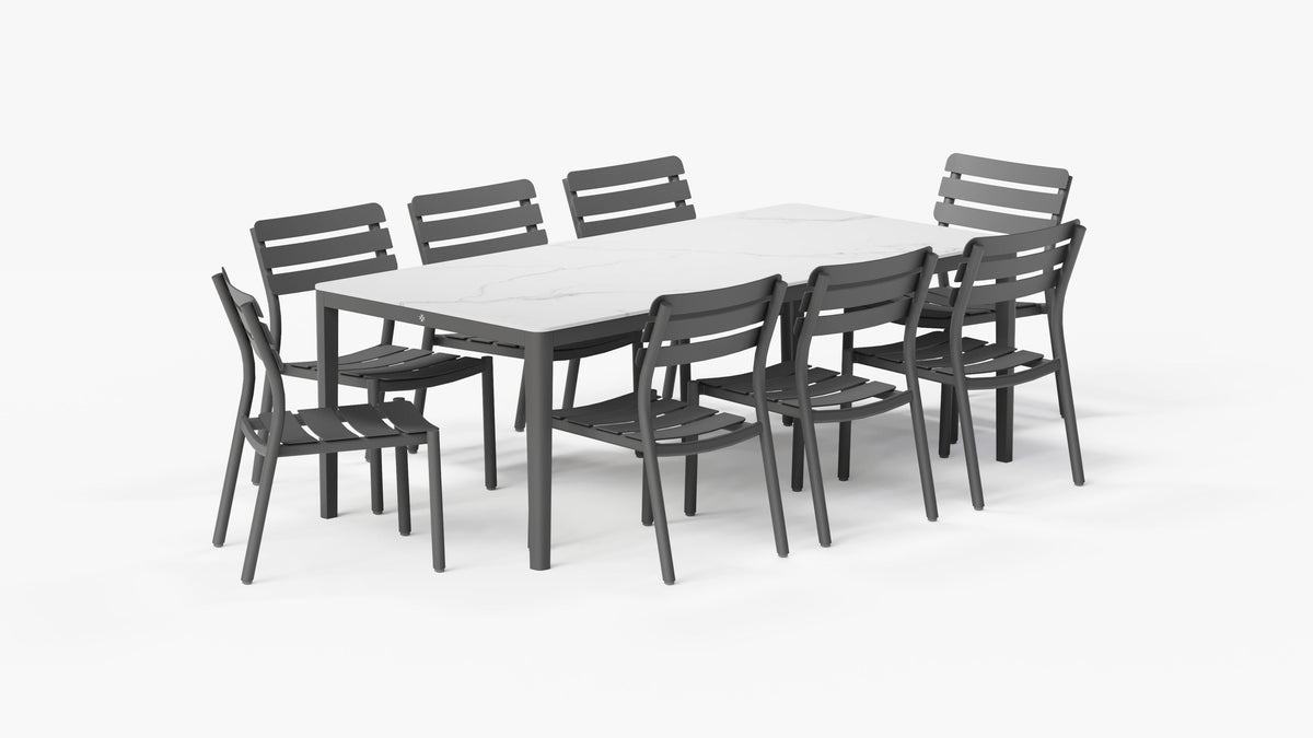 Rectangular outdoor dining table in Glacier White with a marbled sintered stone top, surrounded by eight gray armless aluminum chairs.