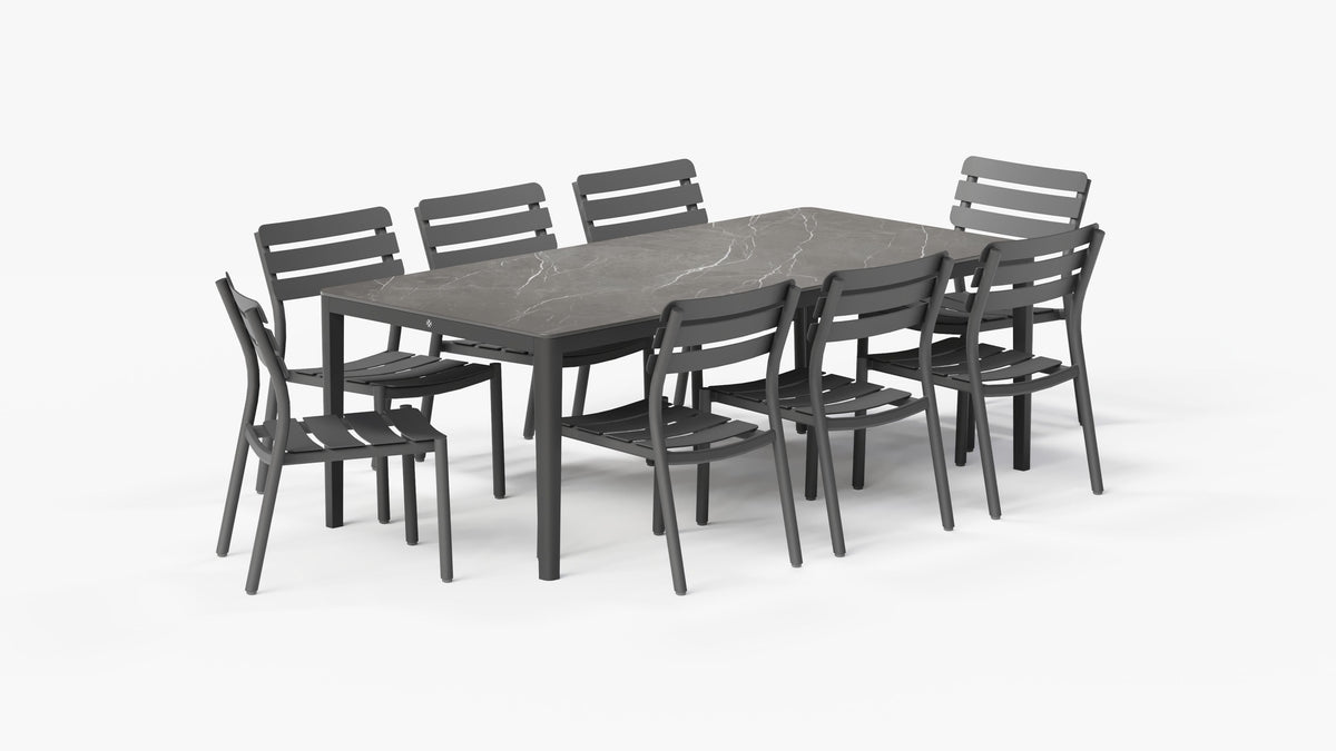 OuterStone® outdoor dining table in Mineral Gray with a marbled surface and eight matching armless aluminum chairs.