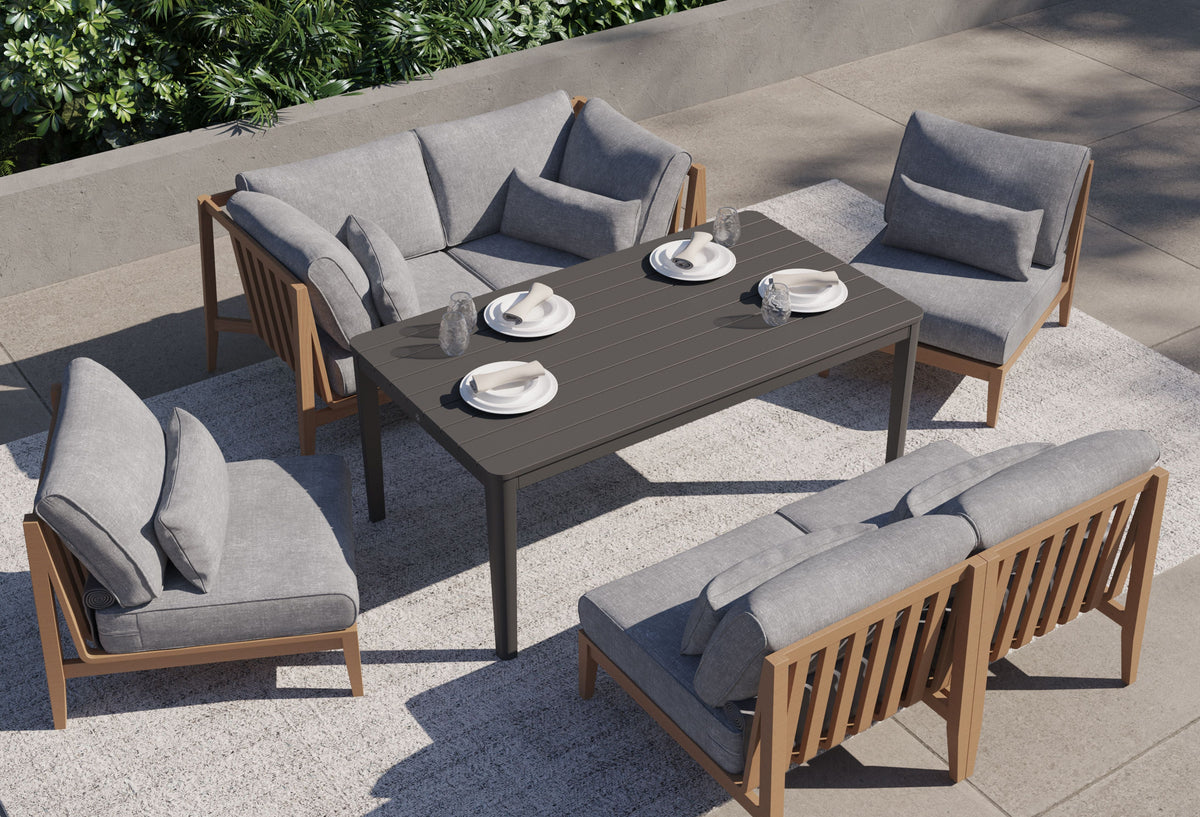 Three-seat outdoor sofa made of FSC-certified teak with gray layered cushions on a concrete patio.