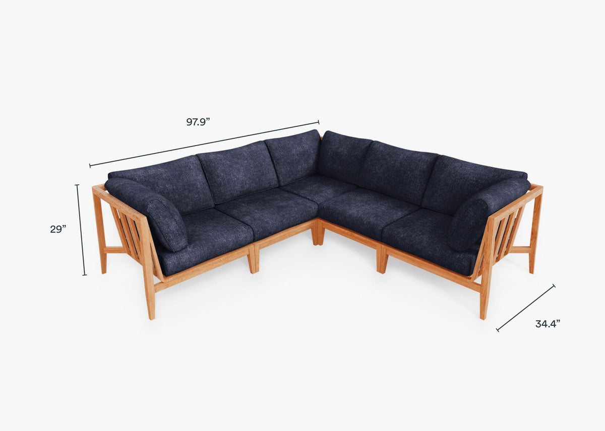 Teak outdoor corner sectional in dark navy with plush cushions and a natural wood frame, designed for five-seat arrangements.