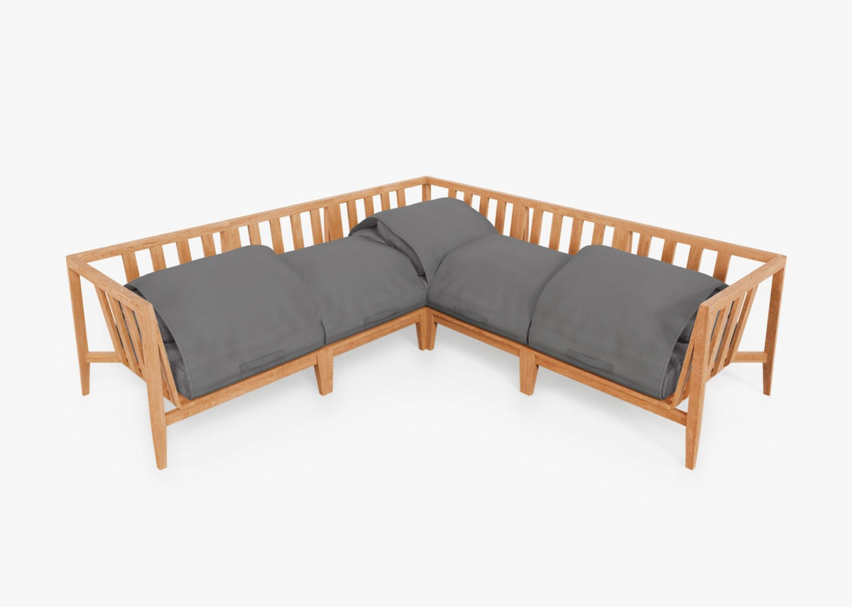 Teak outdoor corner sectional with plush gray cushions, featuring an angular design and slatted sides for airflow.