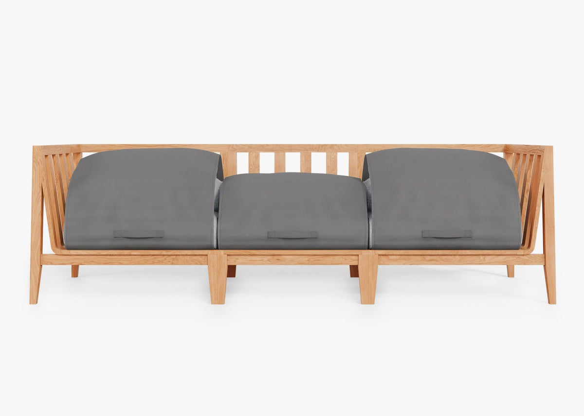 Three-seat outdoor sofa made of light teak wood, featuring gray protective covers over plush cushions.