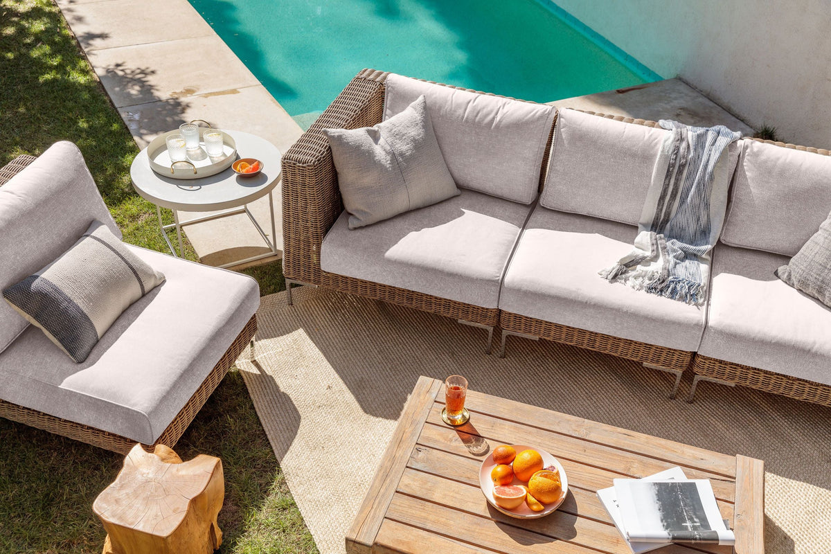 Brown wicker outdoor sofa set with plush neutral cushions, featuring two corner chairs, two armchairs, and an armless chair.