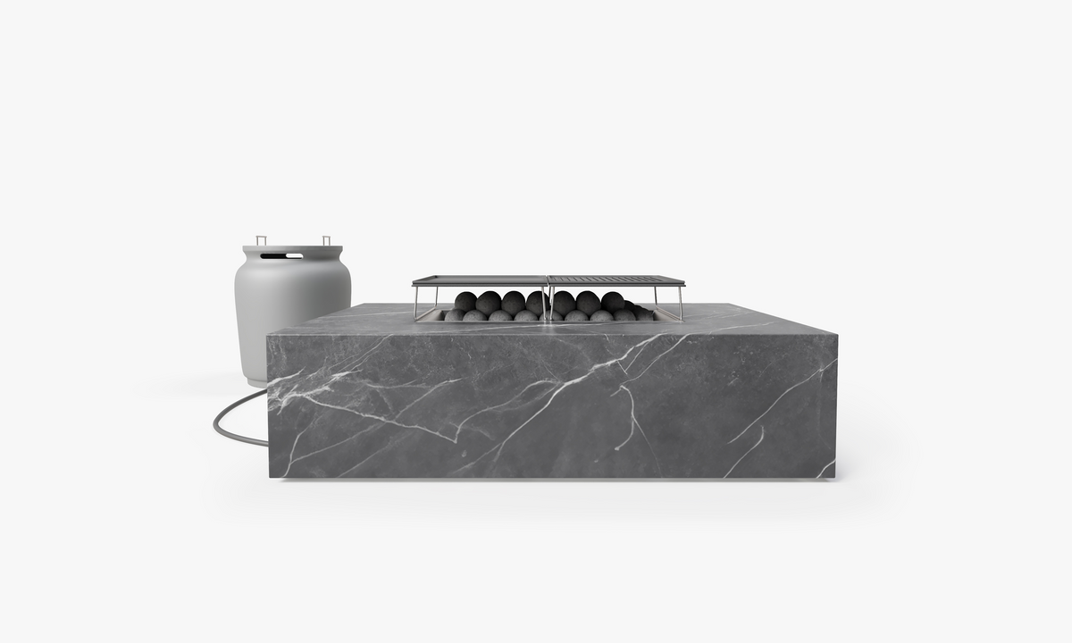 Rectangular fire pit cooking set with a sleek gray sintered stone top, cast-iron griddles, and attached propane tank cover.