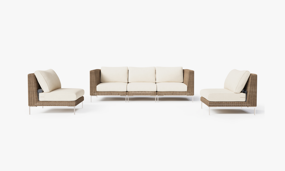 Five-seat outdoor sofa set in handwoven brown wicker with cream cushions; includes two corner and three armless chairs.