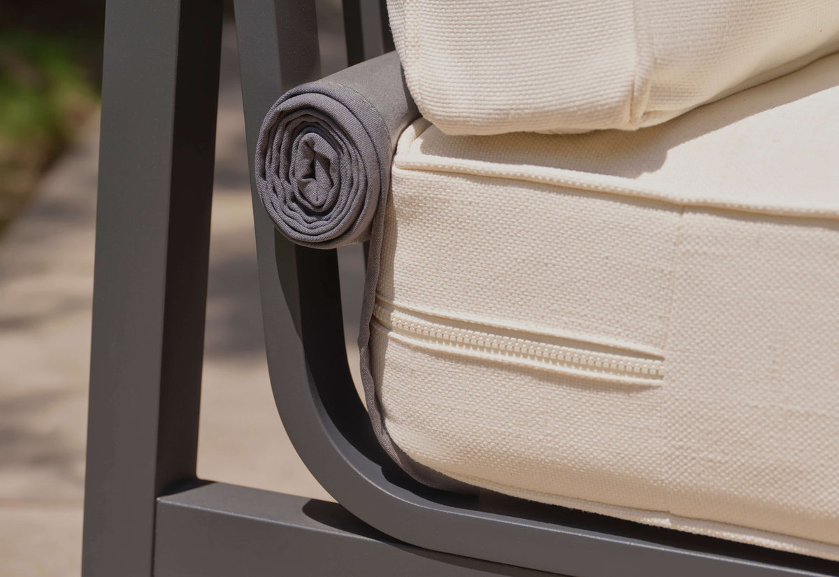 Charcoal aluminum armchair with a rolled gray cushion, featuring a plush fabric cover and sleek design details.