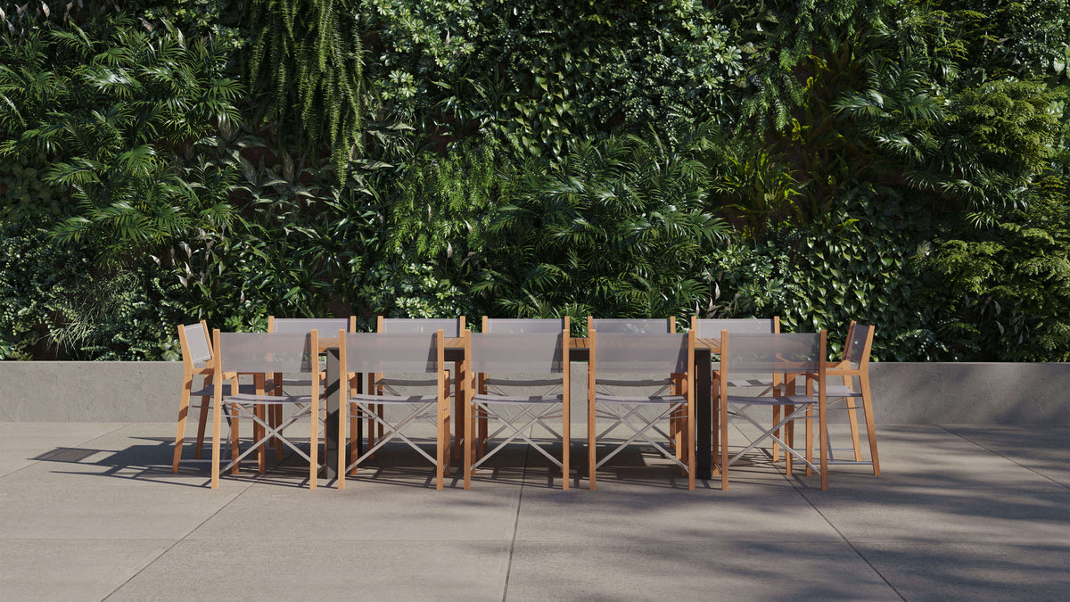 Outer Teak and Aluminum Outdoor Extendable Dining Table with 12 folding teak chairs, featuring a natural wood finish and sleek design.