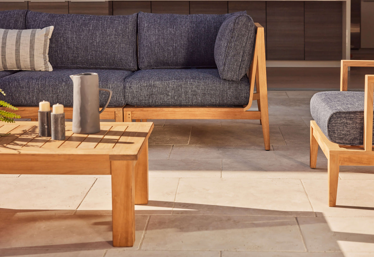 Three-seat outdoor sofa featuring FSC-certified teak frame and dark gray layered cushions, displayed with a wooden coffee table.